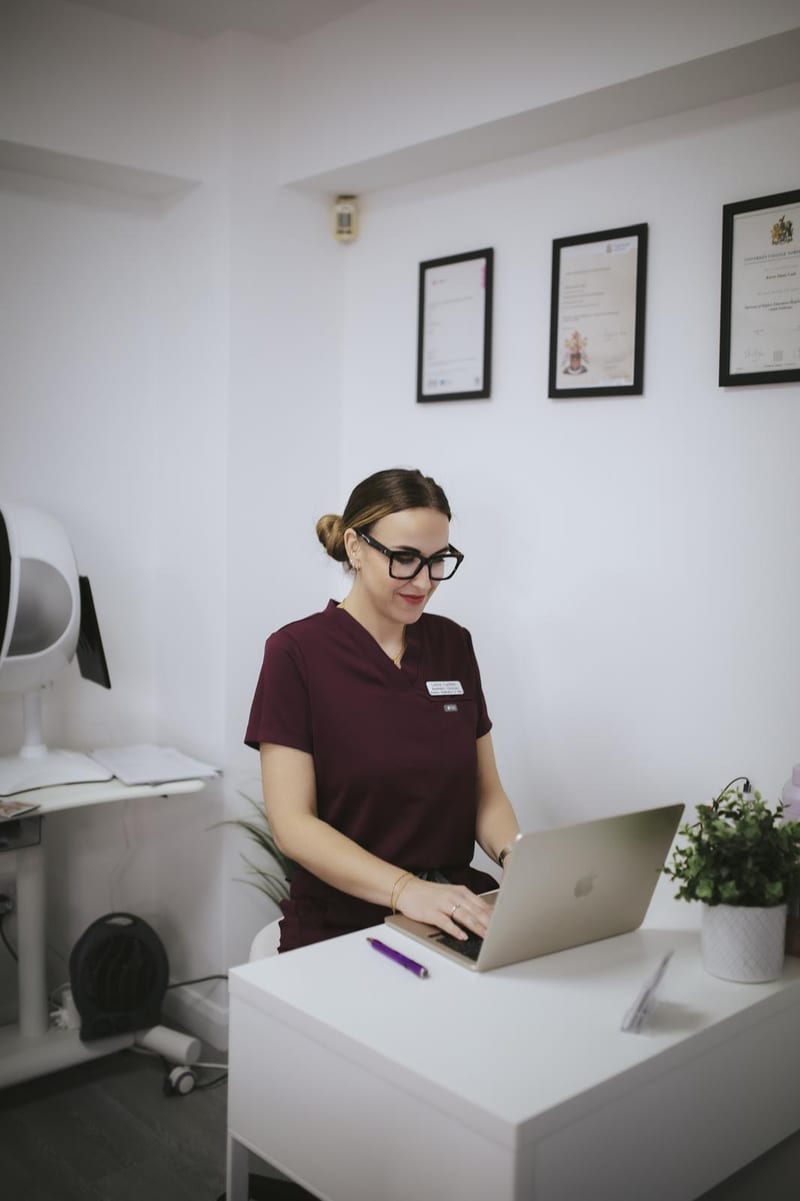 Lorna checking a client's treatment options on the laptop at Avismo Aesthetics and Skin, St Ives